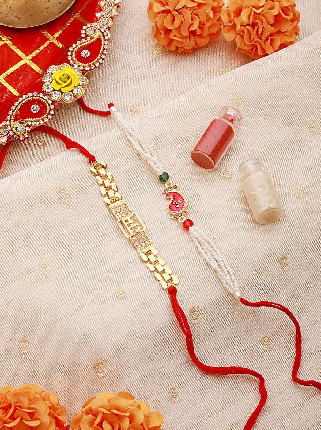 Set Of 2 Gold Toned Ram & Leaf Shaped Pearl Beaded Rakhi With Roli & Chawal